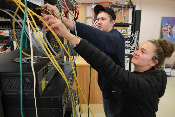 两个学生将电缆插入网络交换机